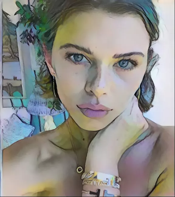 SheLa, a pretty brunette with her hair pulled back, hand to her neck, bangles on the wrist.